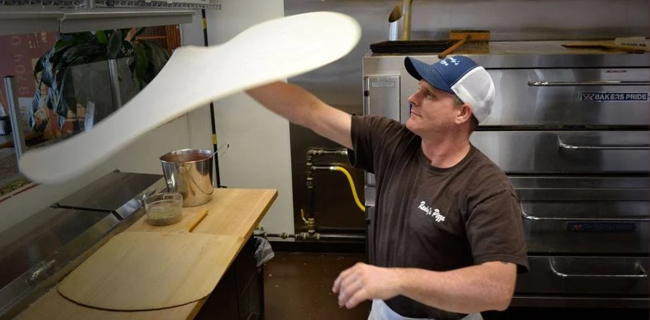 Chef spinning pizza dough in the air