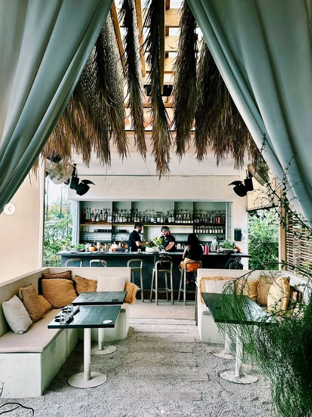 Nomade Cocina’s open-air bar and lounge with a palm-thatched ceiling