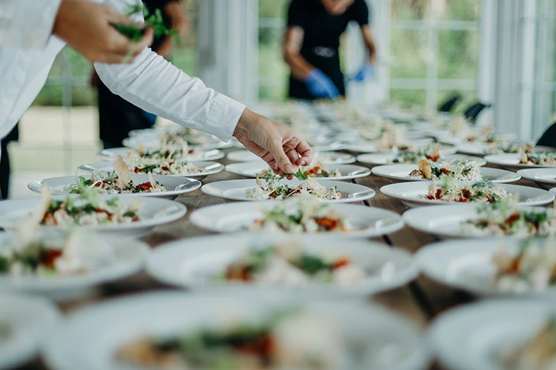 Catering staff plating rows of hors d'oeuvres