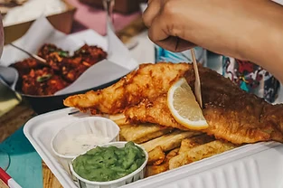 Plated fish and chips meal with dipping sauces