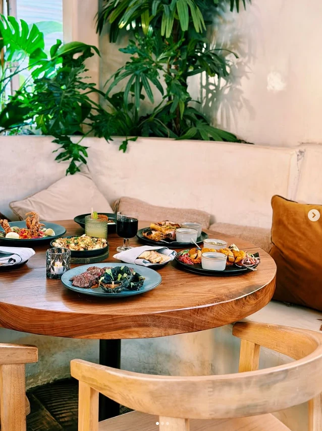 A shared spread of Yucatecan dishes on a round table at Nomade Cocina