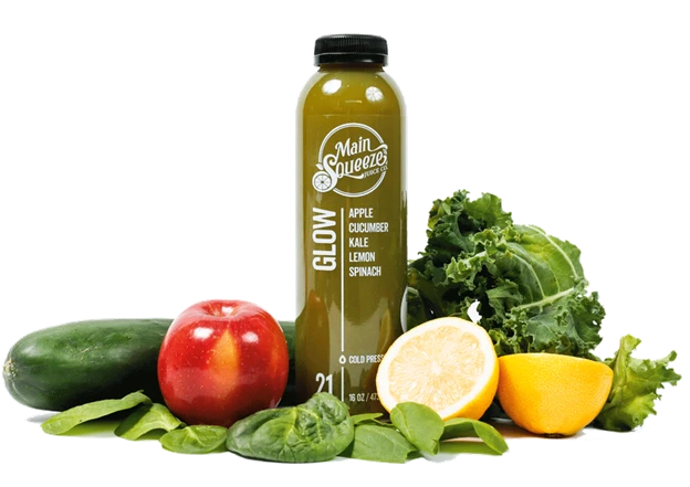 Glow juice bottle surrounded by fresh ingredients: apple, cucumber, kale, lemon, and spinach