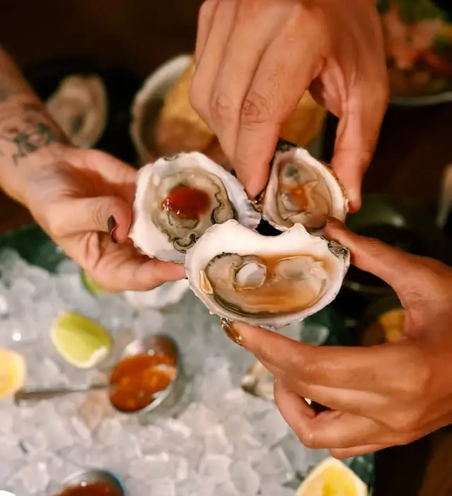 Guests sharing fresh oysters on ice at Nomade Cocina