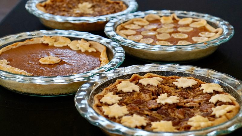 Homemade pumpkin and pecan pies with pastry leaf cutouts