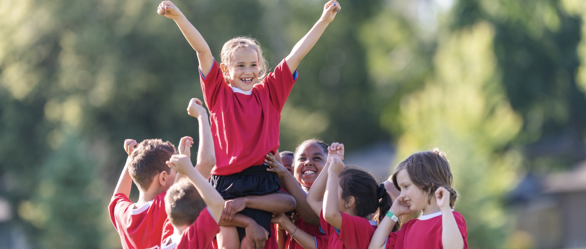 Sports team holding a player up