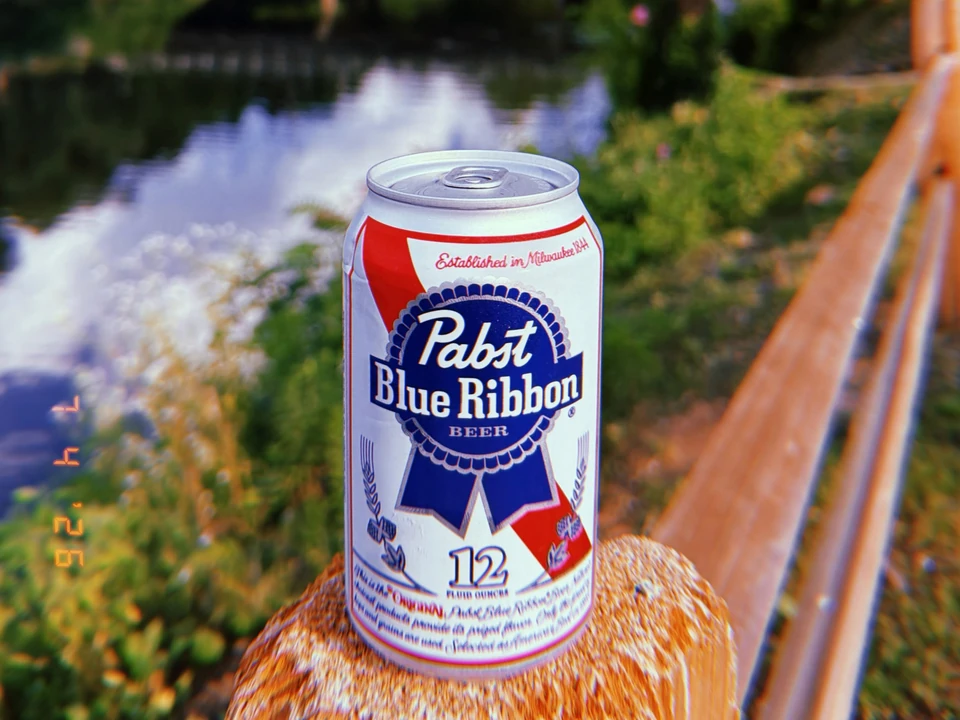 Cold can of beer resting beside the river at Current Tavern