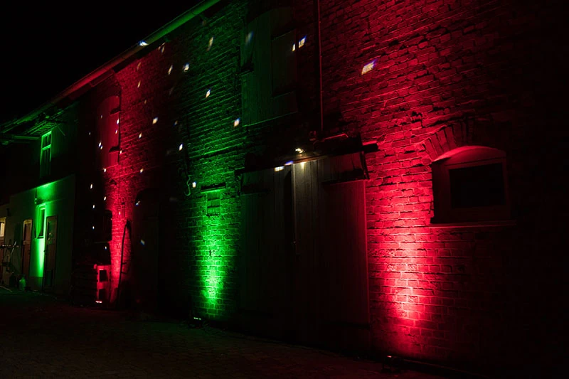 A brick wall washed in coloured event uplighting