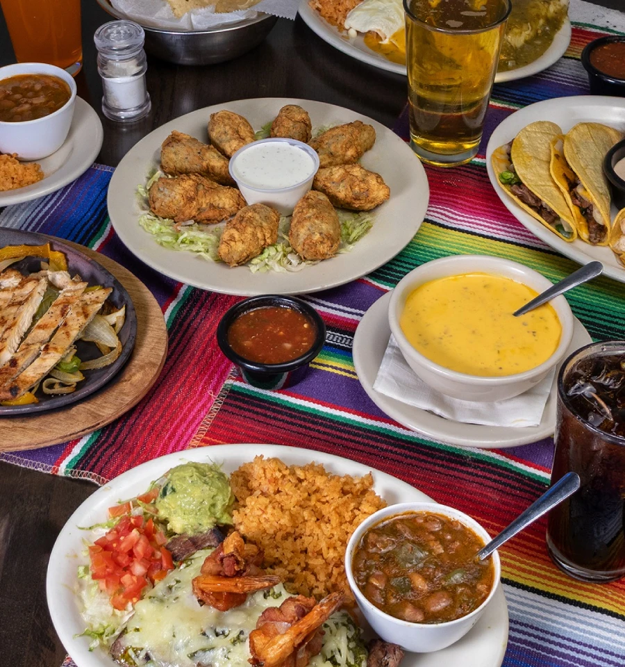 Tex-Mex spread with shrimp, rice, beans, queso, tacos, fajitas, and appetizers at Primo's Tex Mex Grille