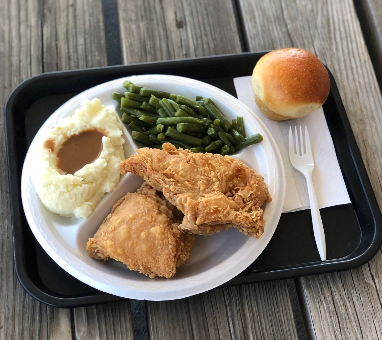 Fried chicken plate with a yeast roll and green beans at Chicken Country