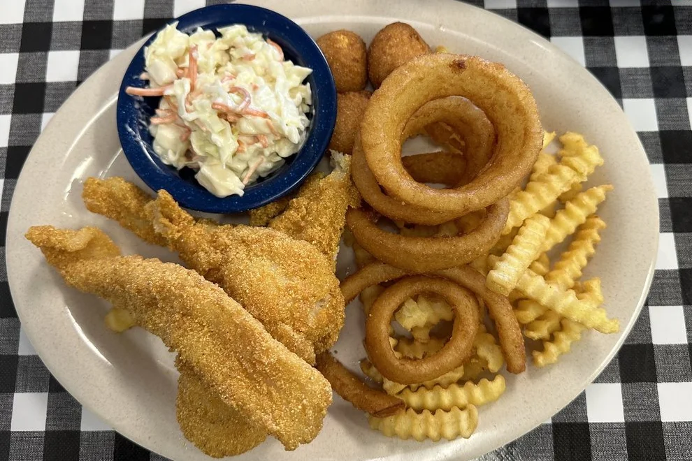 fried catfish with onion rings, french fries, and coleslaw