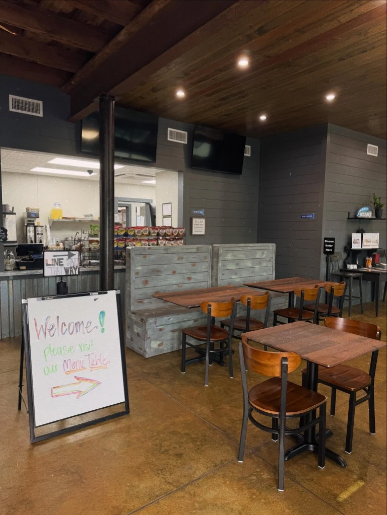 Interior dining area at Passion & Bliss featuring wooden tables, booth seating, and the ordering counter in Leesburg, GA