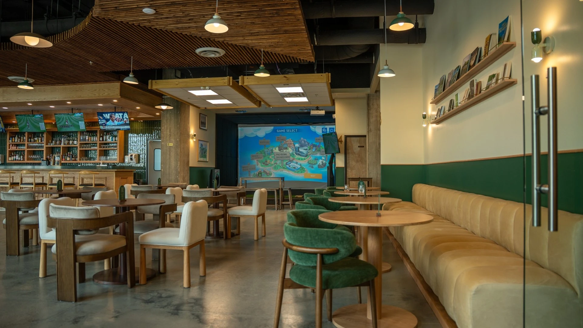 Modern golf entertainment venue dining room with lounge seating, full bar, TVs, and indoor simulator bays