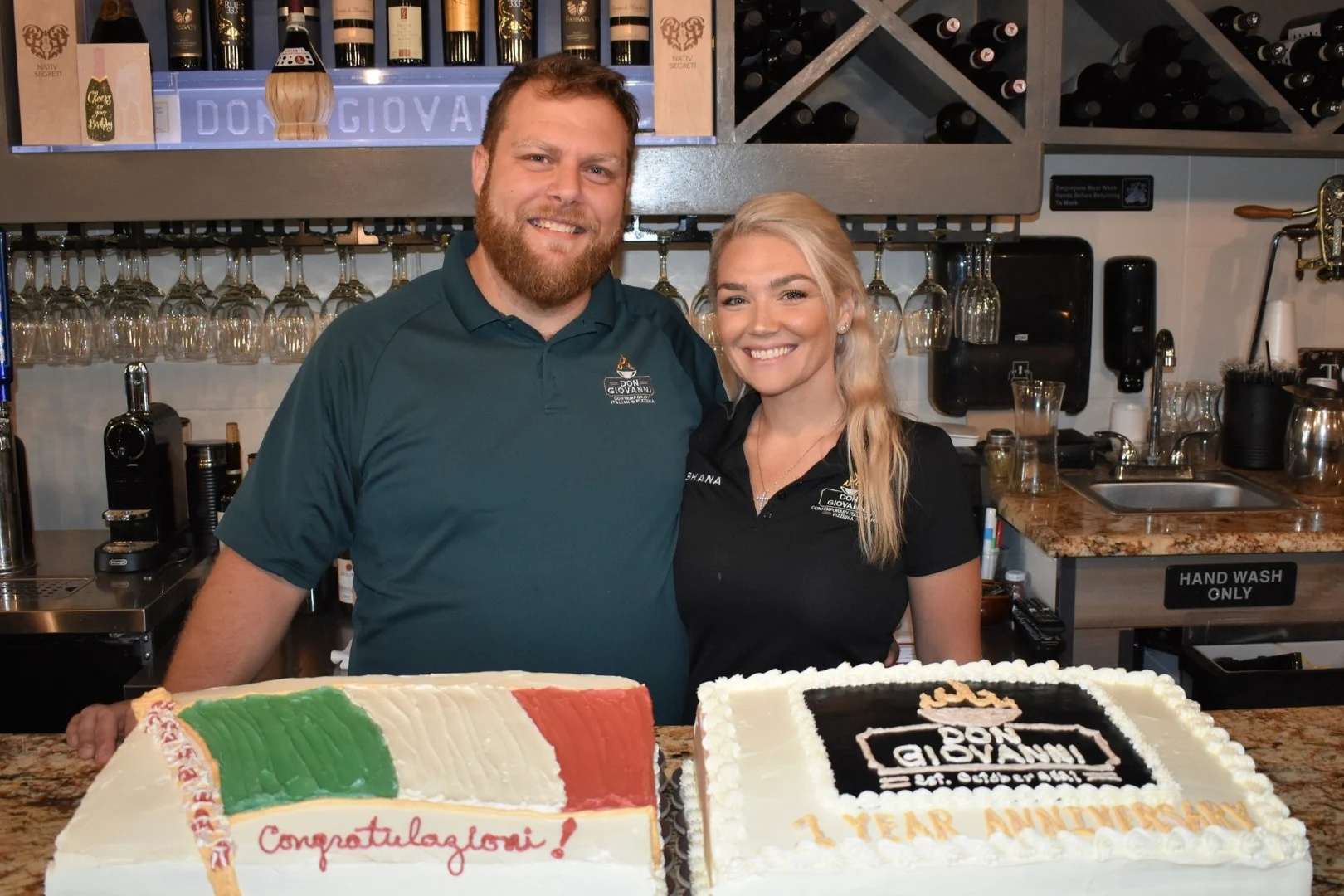 Owners of Don Giovanni standing behind cakes