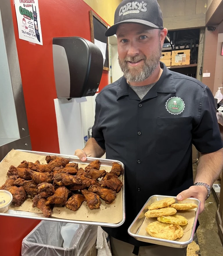 Man holding meals from Corky's Ribs & BBQ Brentwood