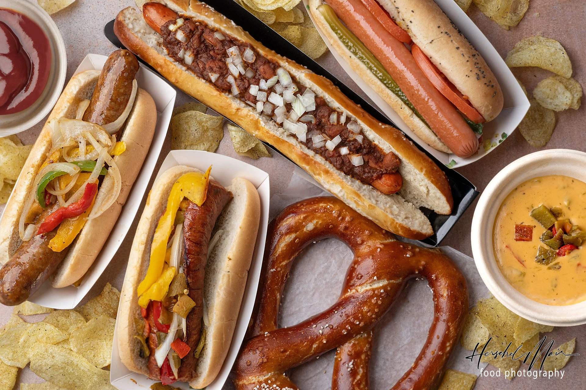 Benny Sausage Company spread with hot dogs, sausages, soft pretzel, chips, ketchup, and cheese dip