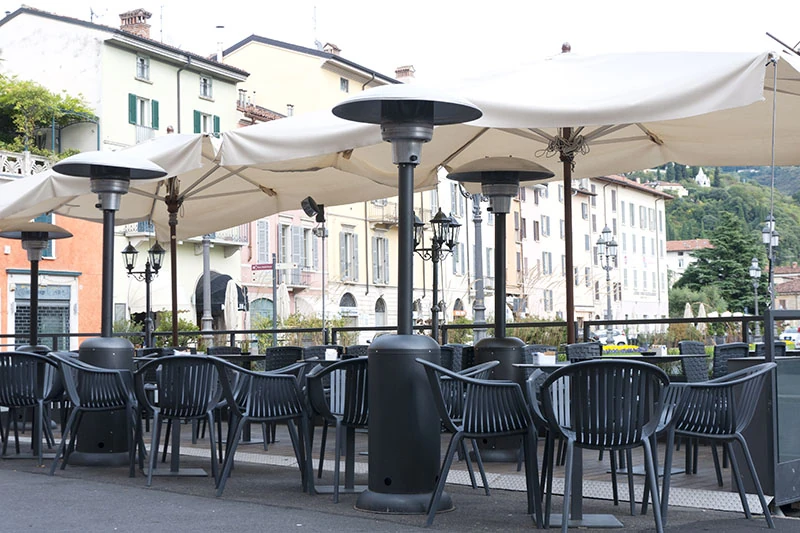 Patio heaters standing among covered outdoor seating