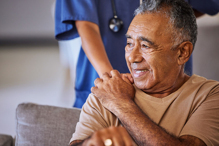 Elderly patient and nurse holding hands