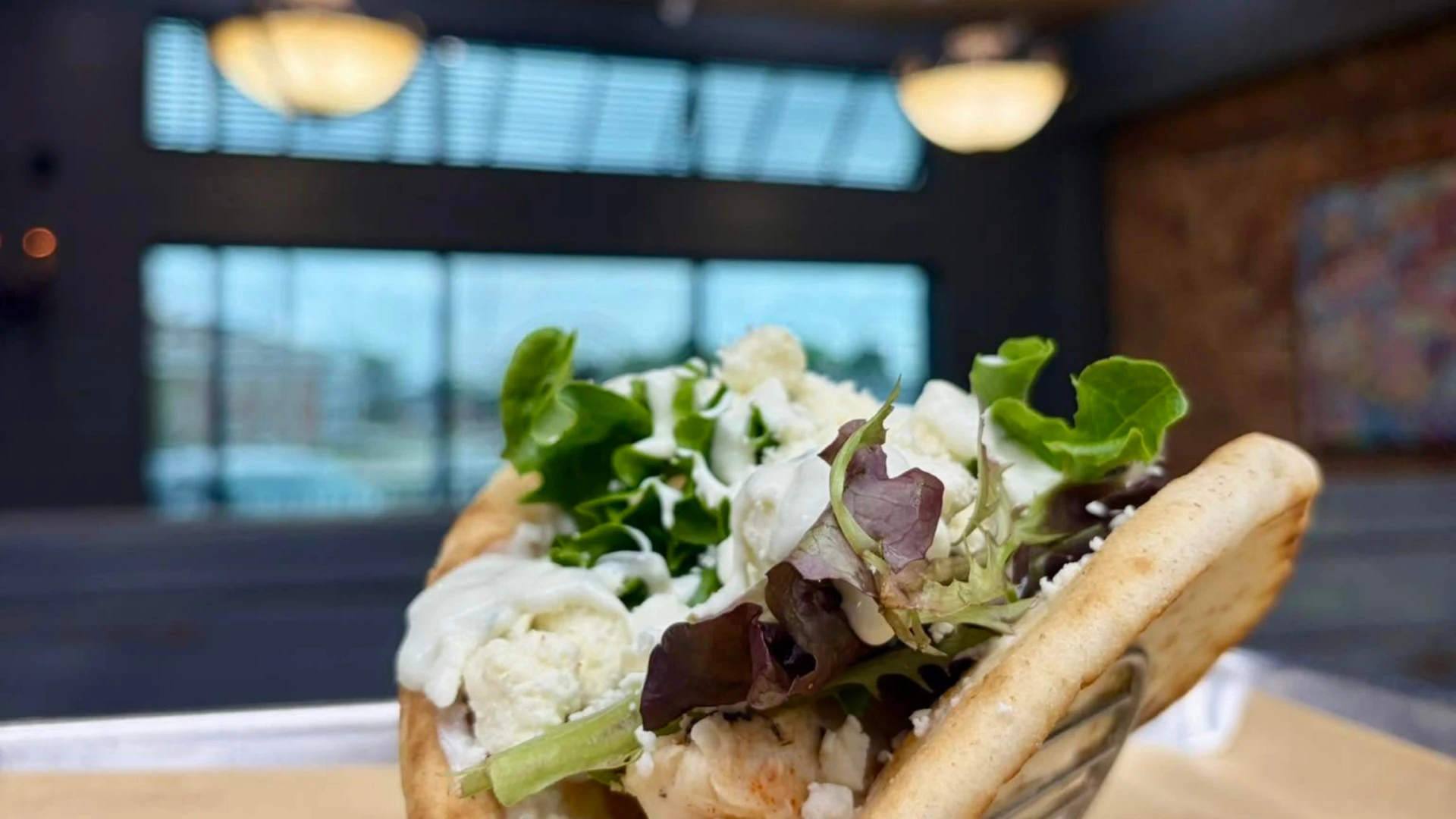 Fresh chicken pita wrap filled with mixed greens and crumbled feta cheese