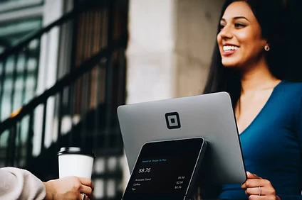 Customer smiling while using a laptop at a cafe table