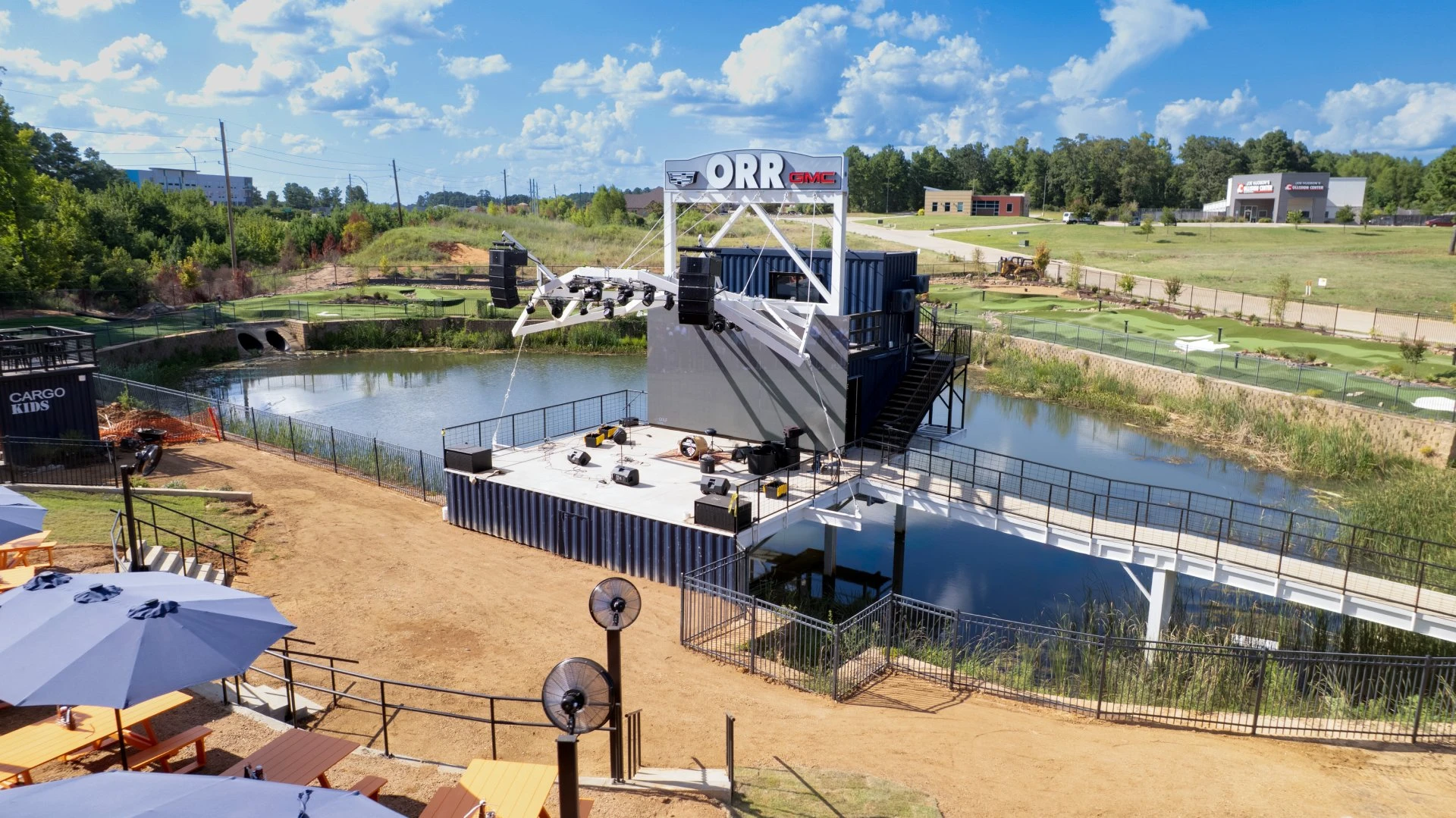 Aerial view of Cargo TX’s outdoor stage, pond, putting course, and patio seating in Longview, TX