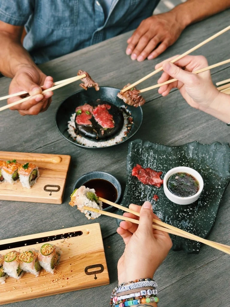 Lucky Robot sushi and dry-aged dishes being shared