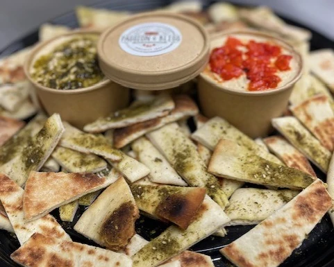 Large catering platter with pita chips and assorted dips