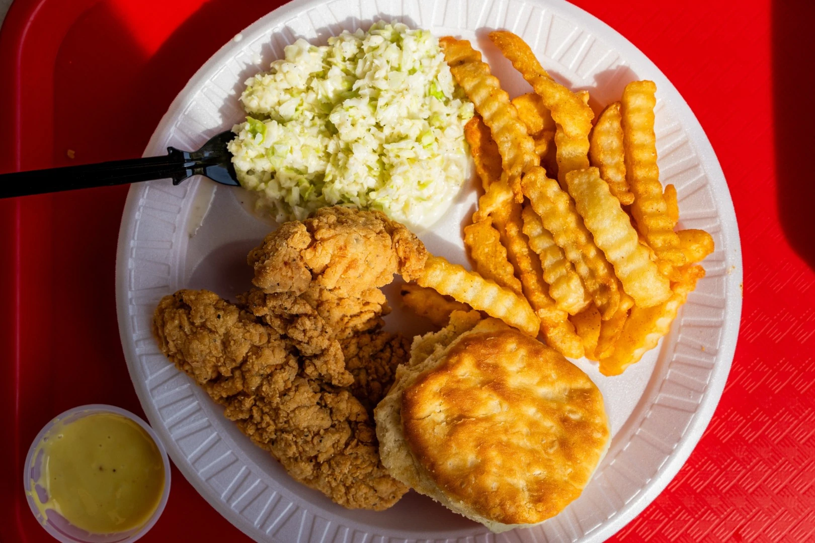chicken fingers and fries with coleslaw and a biscuit