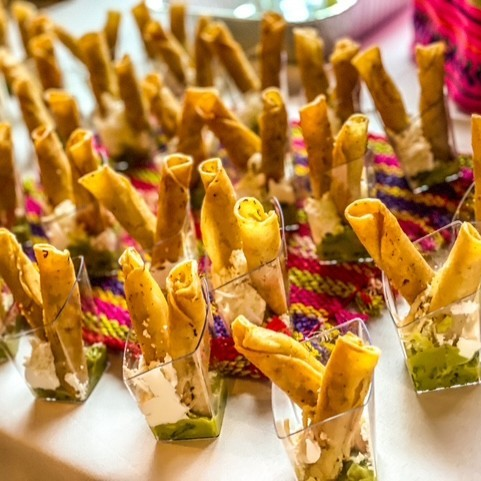 Taquitos inside glasses on catering table