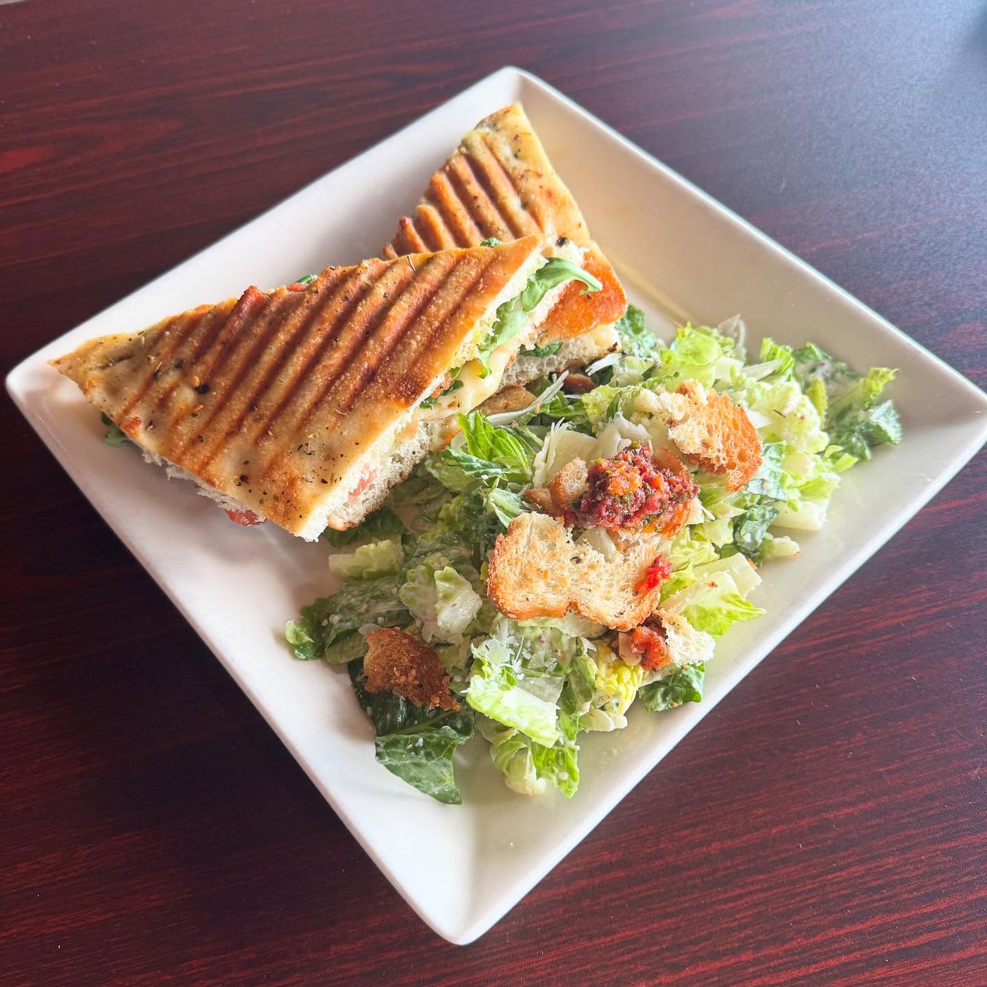 Tiramisu on a plate with chocolate sauce drizzle