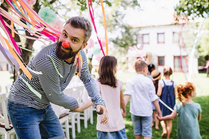 An entertainer leading children at a birthday party