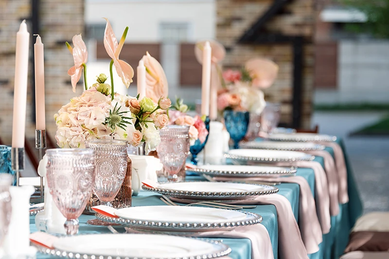 A table dressed in patterned linens with florals and glassware