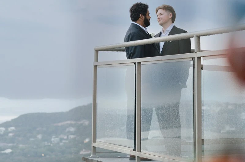 Two grooms on a deck overlooking the Hill Country at The Oasis