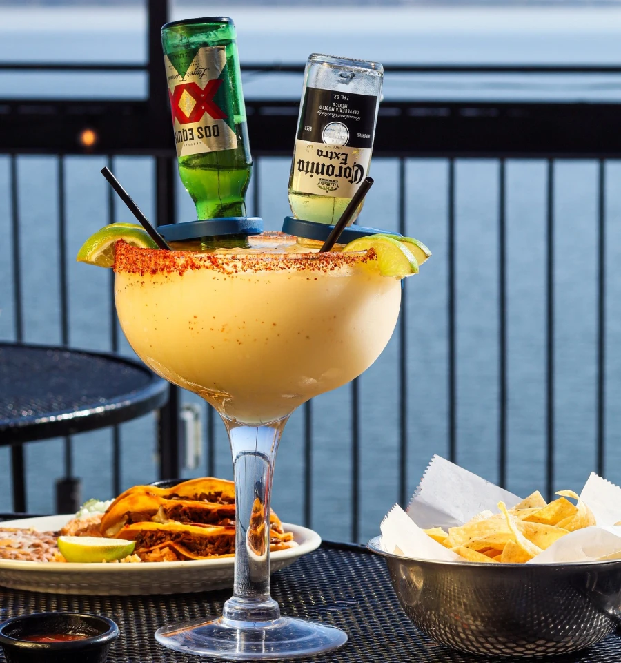 Large margarita with Dos Equis and Corona bottles served with chips and tacos at Primo's Tex Mex Grille