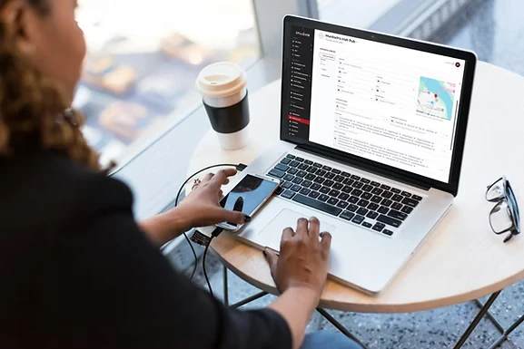 Restaurant owner updating their Business Center profile on a laptop at a cafe table