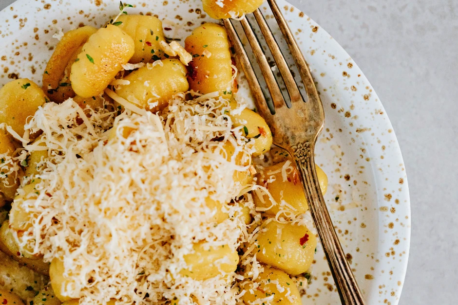 Gnocchi pasta with shredded cheese on top