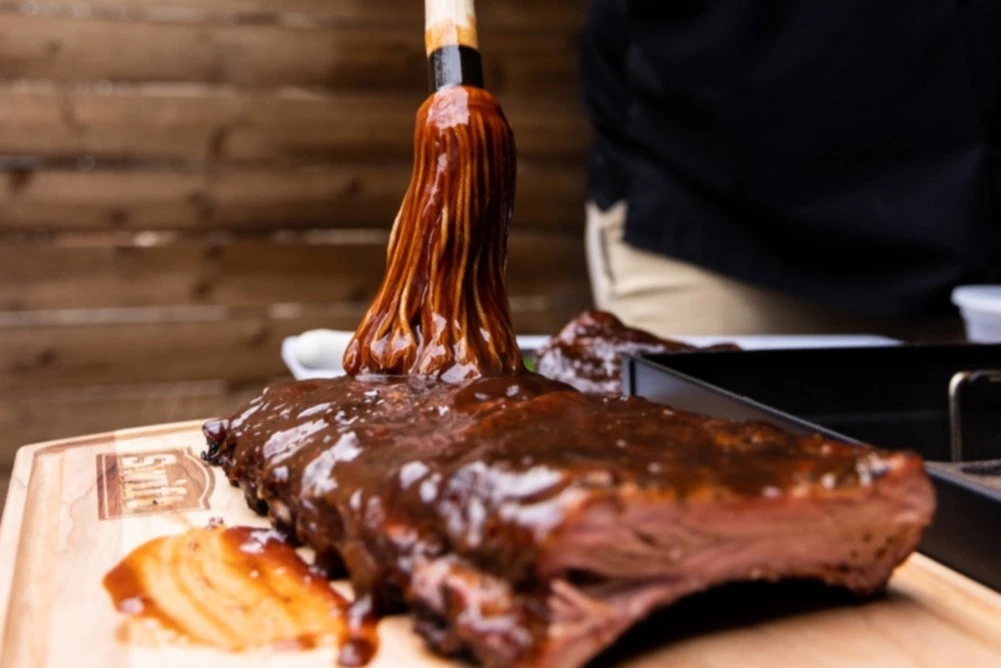 brisket being rubbed with bbq sauce