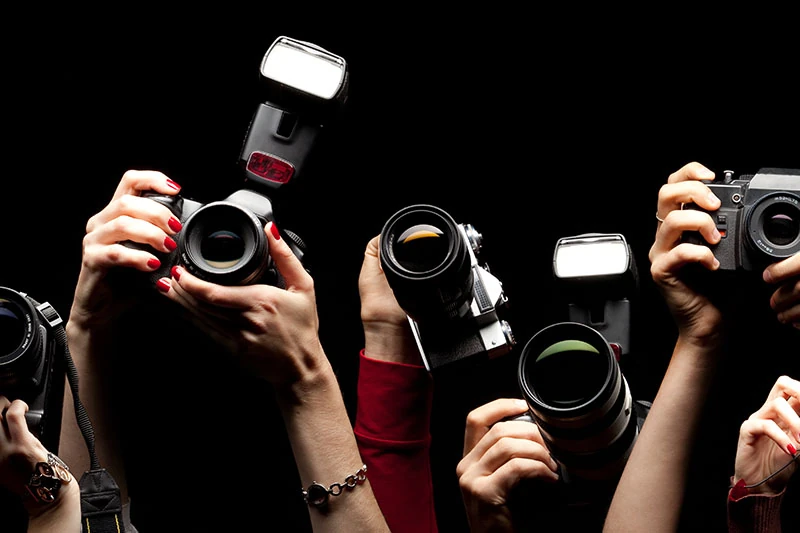 Cameras raised to photograph an event