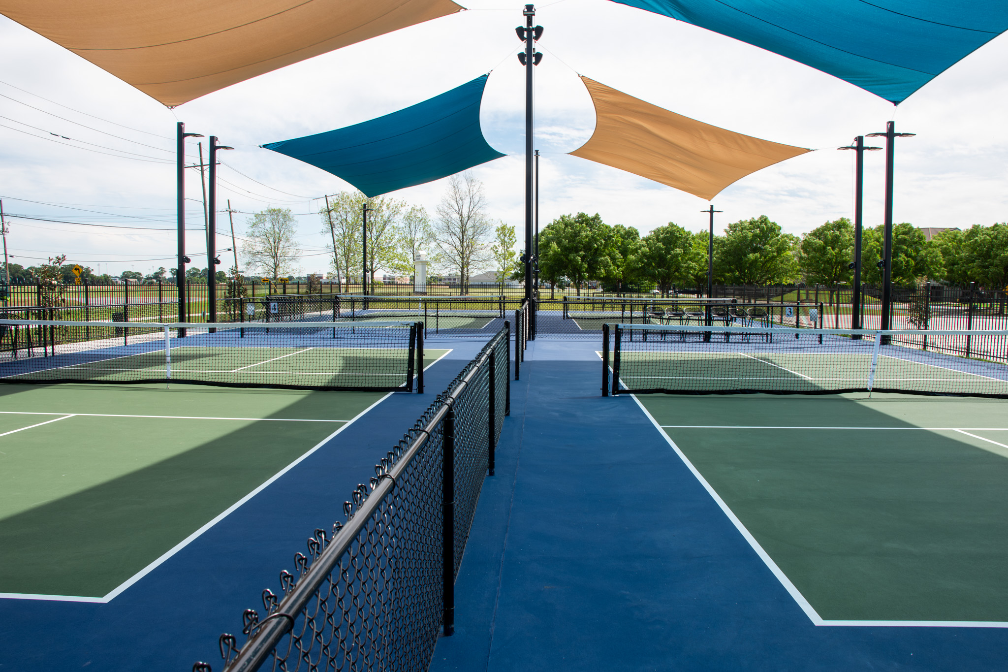 Pickleball courts under teal and tan shade sails