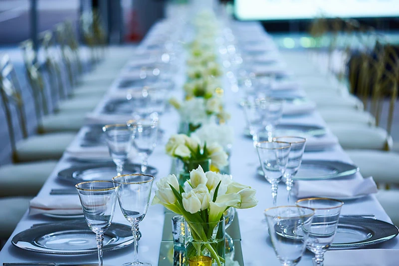 Dinner party floral arrangements lining a long table