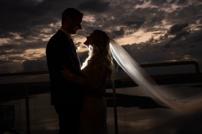 Bride and groom at sunset with the veil flowing in the wind at The Oasis