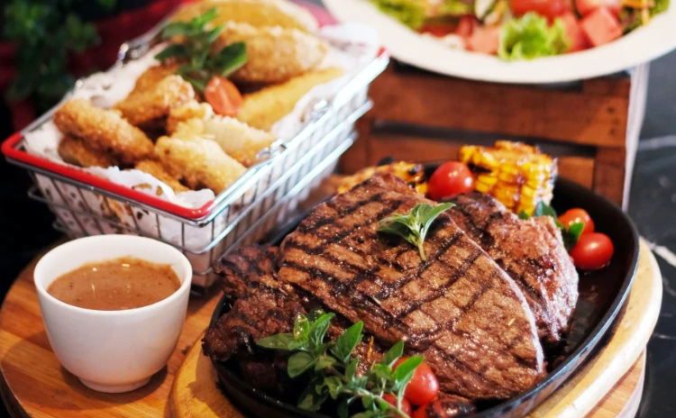 Steak served with corn and soup.