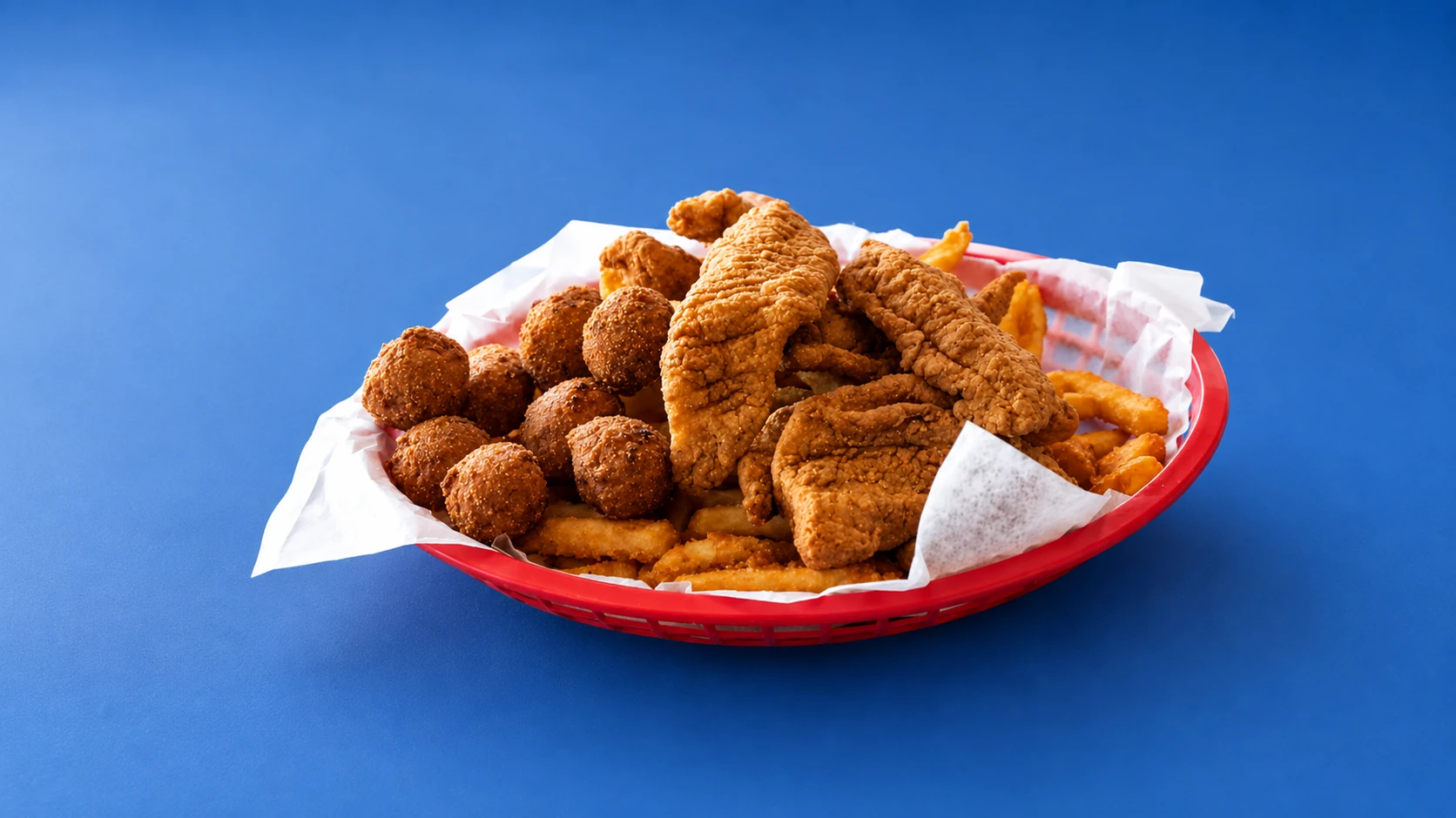 Basket of hand-breaded catfish, chicken tenderloins, hush puppies and fries at Petty's