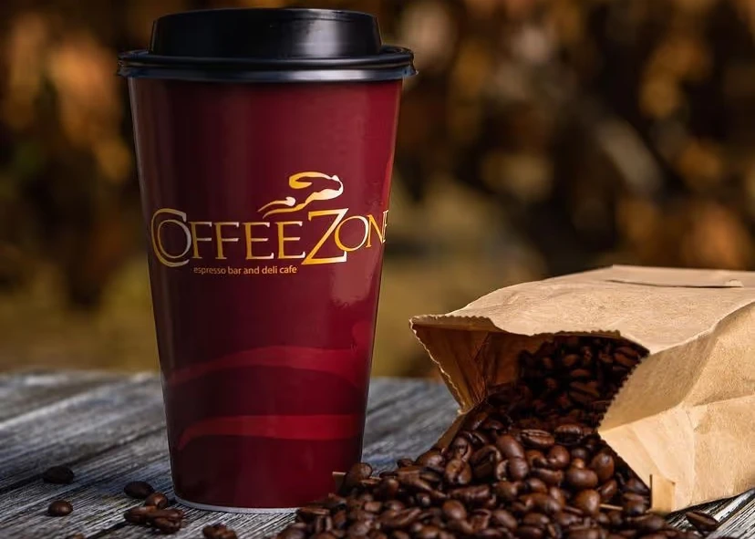 Cup Coffee Zone branded of coffee and a bag of coffee beans