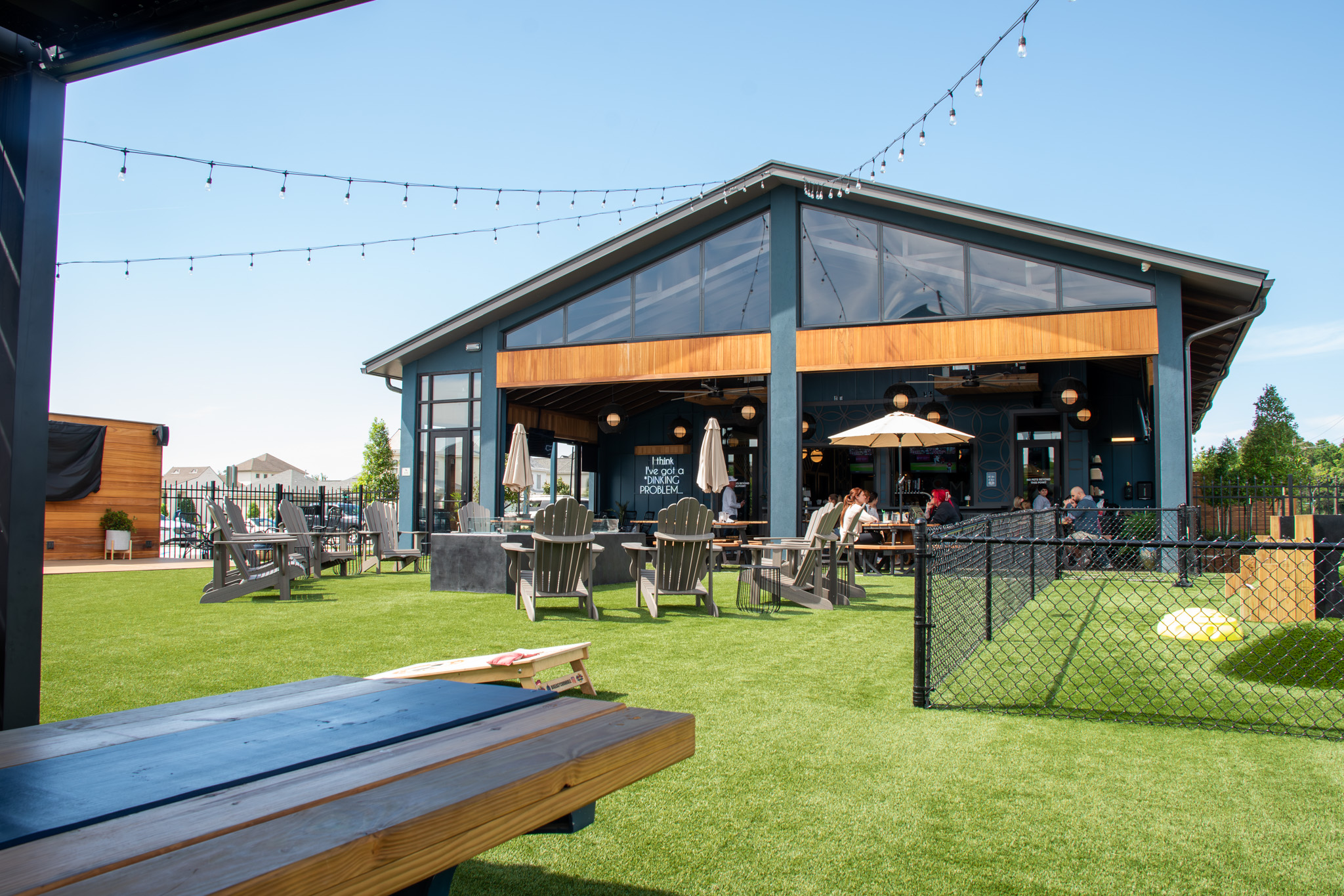 SMASH outdoor turf area with Adirondack chairs, string lights, and the open-air patio