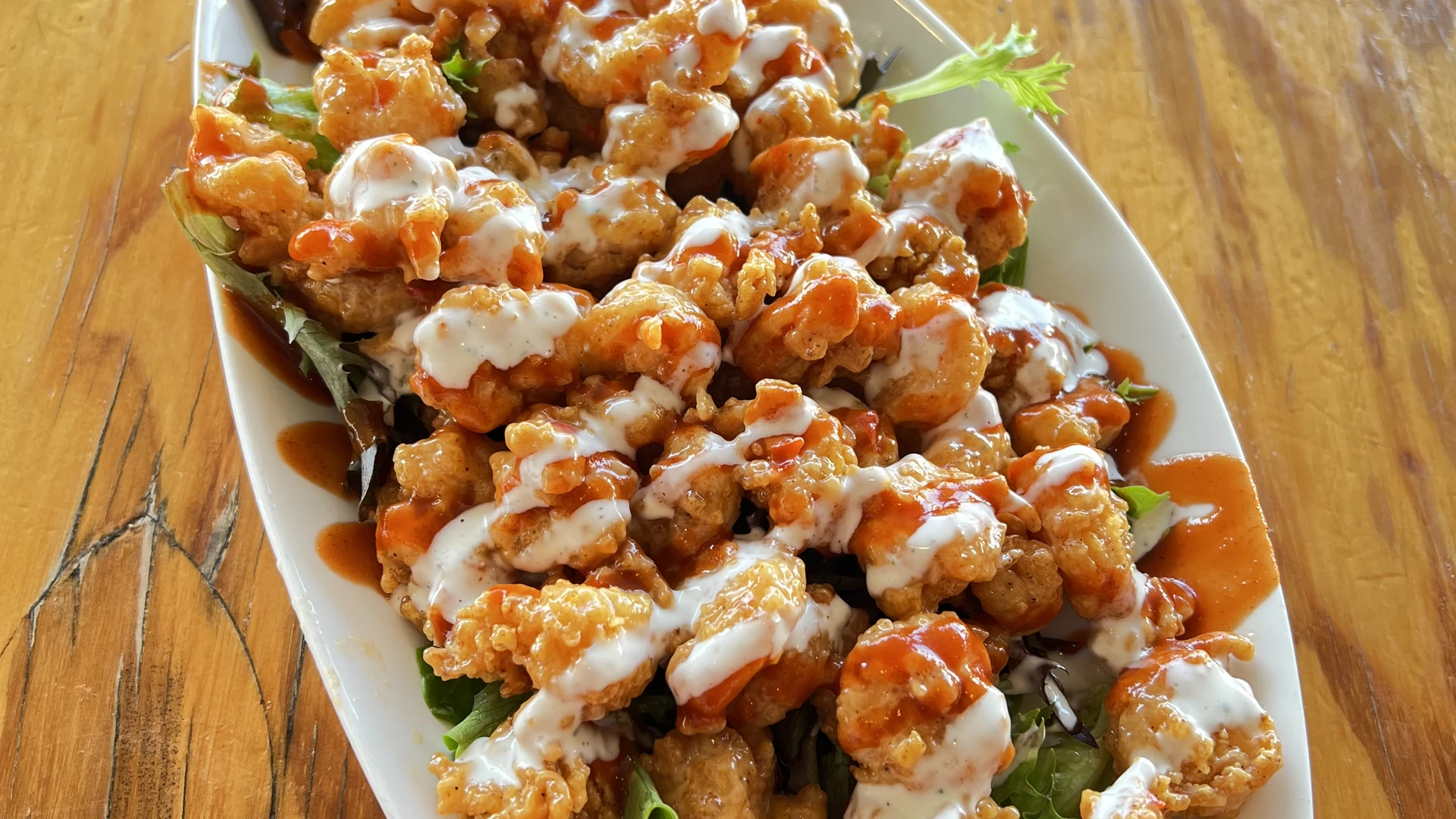 Crispy fried shrimp tossed in sweet and spicy sauce over fresh mixed greens.
