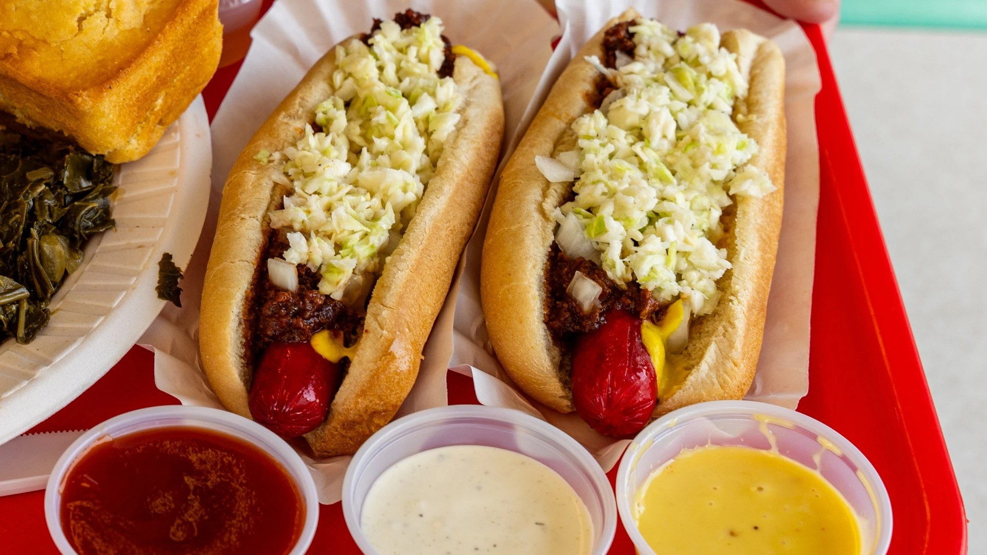 two hot dogs with onions and other toppings