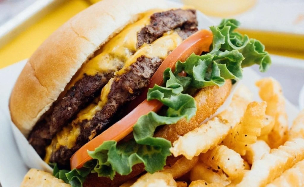 Cheeseburger with lettuce, tomato, and fries at Brews N Paws