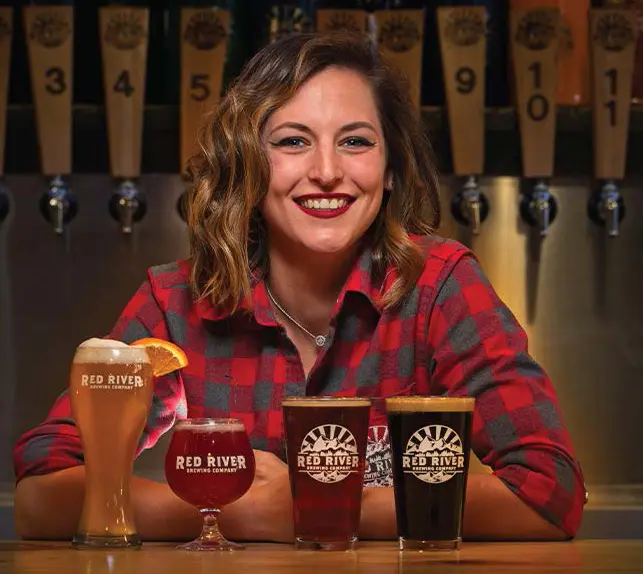 Women with variety of beer infront on table